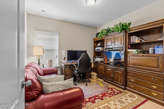 carpeted office with a textured ceiling