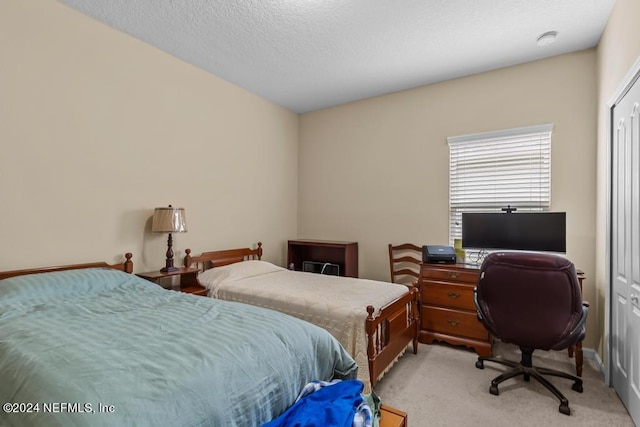 bedroom featuring light carpet and a textured ceiling