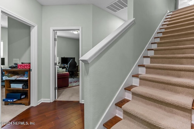 stairway featuring dark wood-type flooring