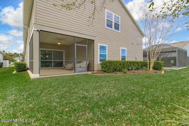 back of house with a lanai and a yard