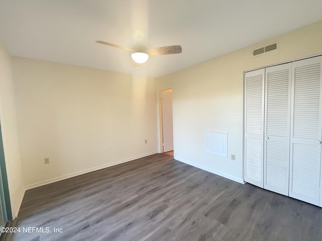 unfurnished bedroom with ceiling fan, a closet, and dark wood-type flooring