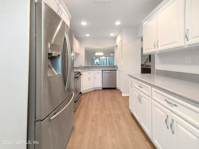 kitchen with white cabinets, light hardwood / wood-style floors, kitchen peninsula, and stainless steel appliances