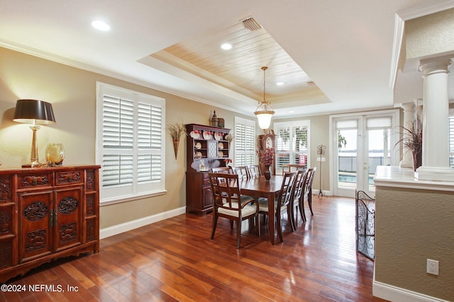 dining room featuring french doors, a tray ceiling, ornate columns, and dark hardwood / wood-style floors