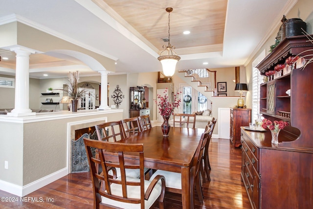 dining space featuring dark wood-style flooring, baseboards, ornate columns, a raised ceiling, and crown molding