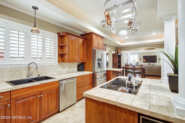 kitchen featuring decorative columns, arched walkways, a sink, stainless steel appliances, and backsplash