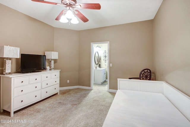 bedroom with light colored carpet, ceiling fan, ensuite bath, and baseboards