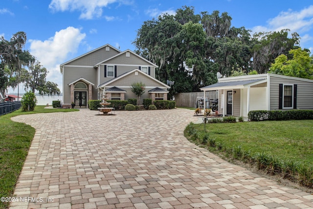 view of front of home featuring french doors, a front yard, and fence