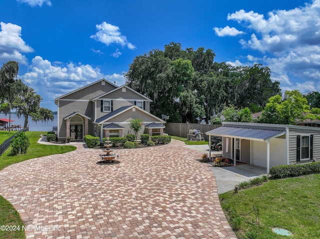 view of front of house featuring a garage, fence, a front lawn, and decorative driveway