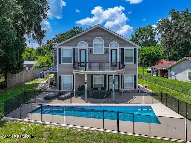 rear view of property featuring a yard, a patio area, and fence