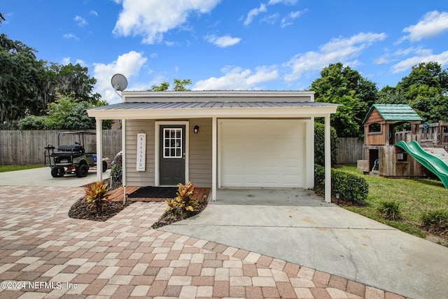 view of front of home with a garage and a playground