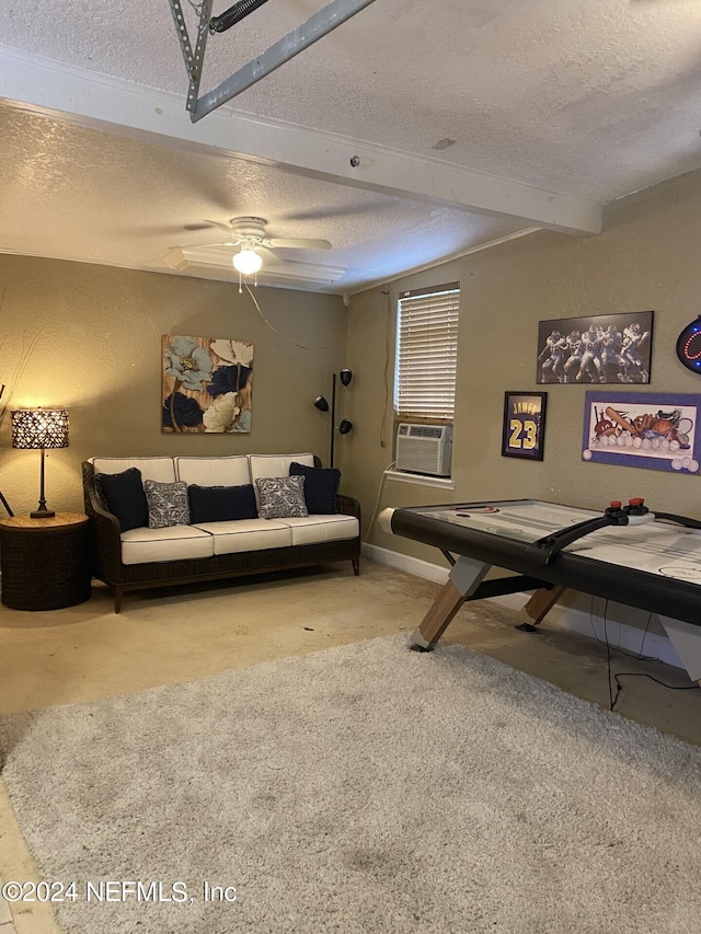 living area with a textured ceiling, a textured wall, cooling unit, a ceiling fan, and beam ceiling