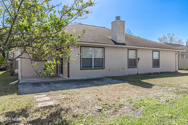 rear view of property featuring a yard and a patio