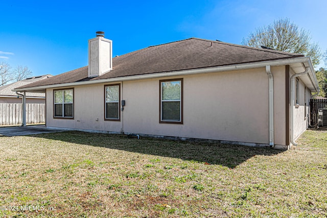 back of house with a lawn