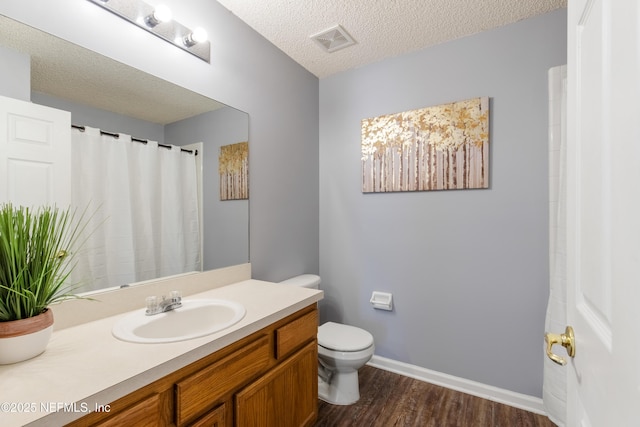 bathroom with vanity, hardwood / wood-style floors, a textured ceiling, and toilet