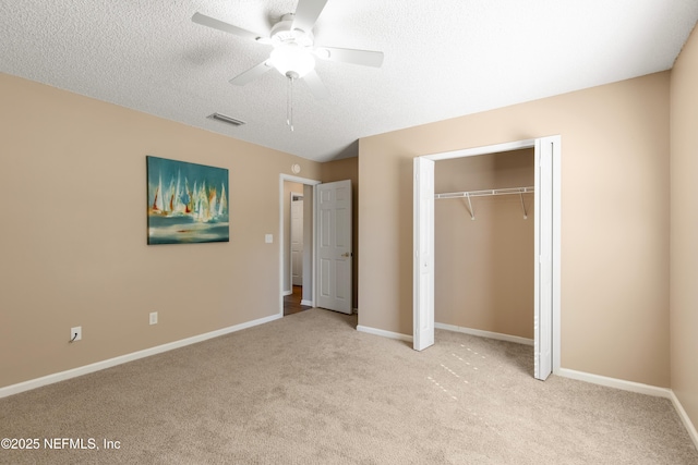 unfurnished bedroom with a textured ceiling, ceiling fan, light carpet, and a closet