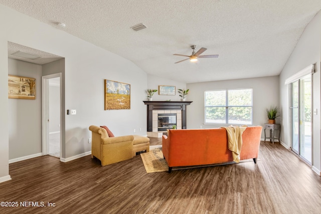 living room with a fireplace, dark hardwood / wood-style flooring, a textured ceiling, and ceiling fan