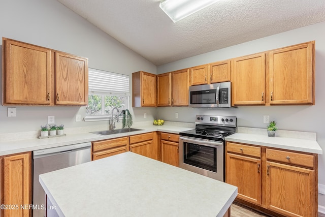 kitchen with sink, stainless steel appliances, light hardwood / wood-style floors, a textured ceiling, and lofted ceiling