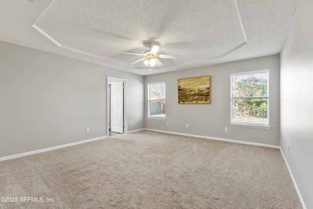 empty room with ceiling fan, a textured ceiling, and light carpet