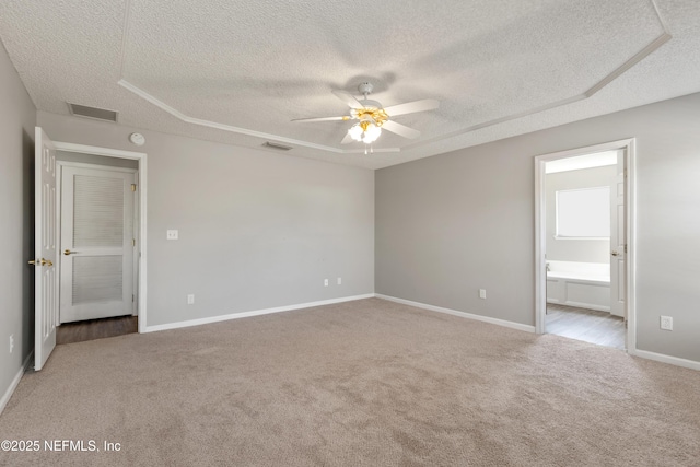 empty room with light carpet, ceiling fan, and a textured ceiling