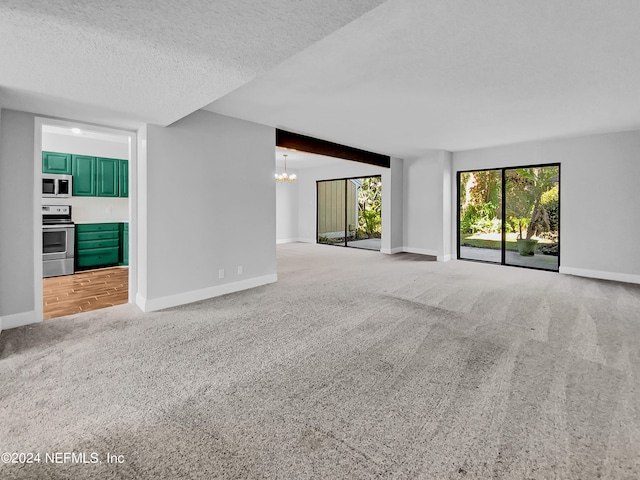 unfurnished living room featuring a textured ceiling, a chandelier, and light wood-type flooring