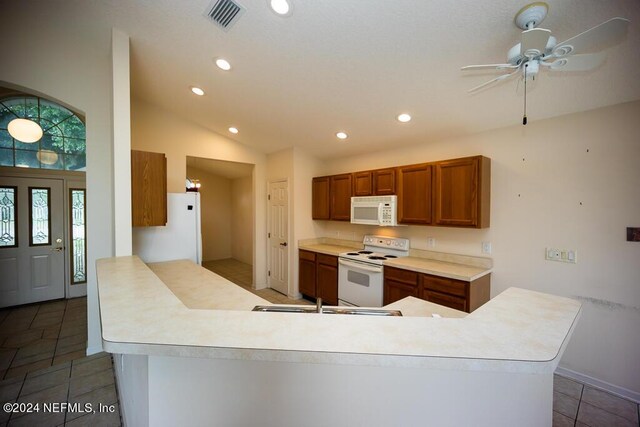 kitchen with tile patterned flooring, ceiling fan, white appliances, and kitchen peninsula