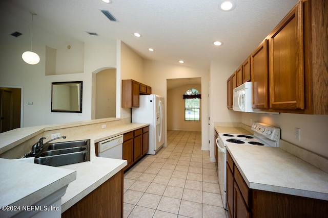 kitchen featuring white appliances, light tile patterned floors, hanging light fixtures, vaulted ceiling, and sink