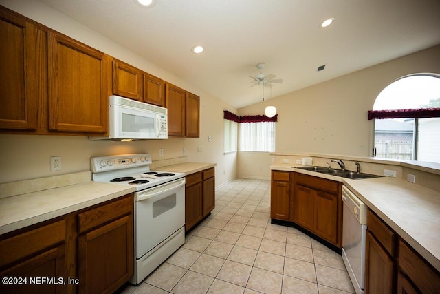 kitchen with lofted ceiling, sink, white appliances, light tile patterned floors, and ceiling fan