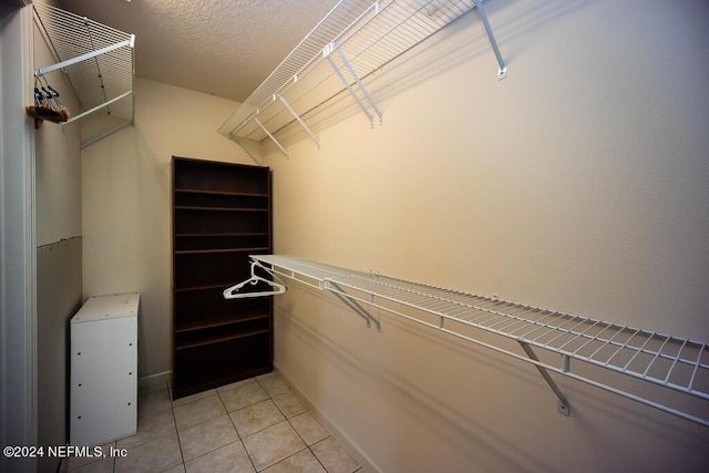 walk in closet with light tile patterned floors