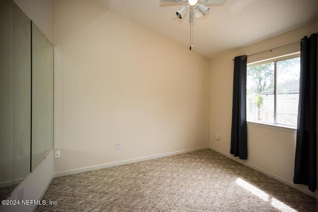 unfurnished room featuring vaulted ceiling, carpet, and ceiling fan