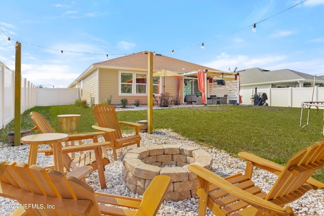 back of property featuring a lawn, a patio area, and a fire pit