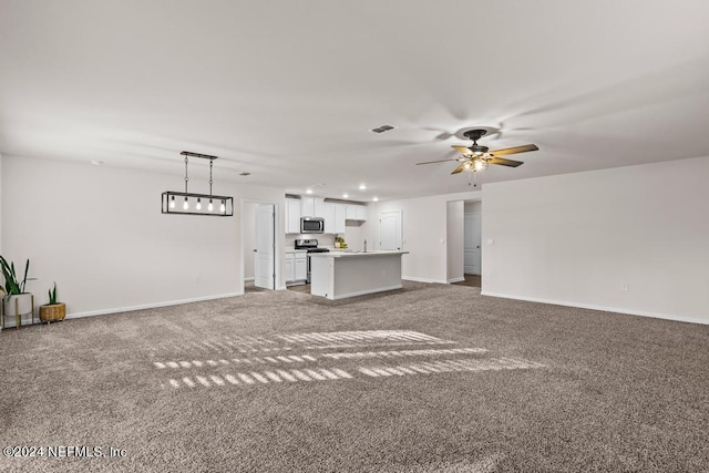 unfurnished living room with ceiling fan and carpet