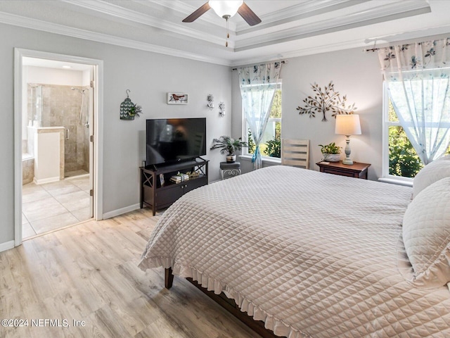 bedroom with a raised ceiling, light hardwood / wood-style flooring, crown molding, and ensuite bathroom