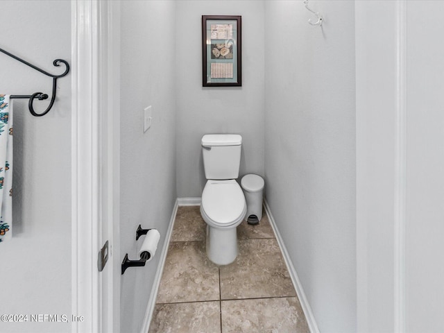 bathroom featuring tile floors and toilet