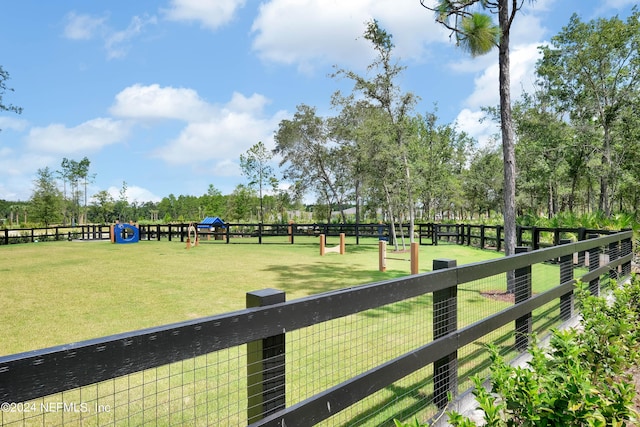 surrounding community with fence and a yard