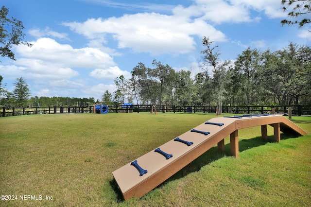 view of home's community with a yard and fence