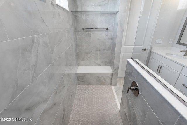 full bath with tiled shower and vanity