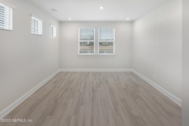 unfurnished room with recessed lighting, visible vents, light wood-style flooring, and baseboards