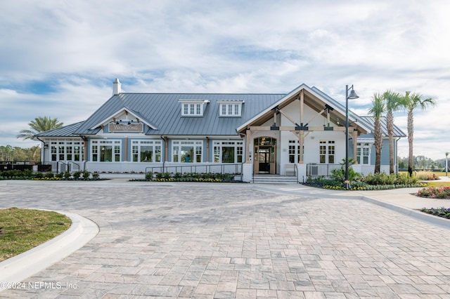 view of front of property with a standing seam roof, a chimney, and metal roof