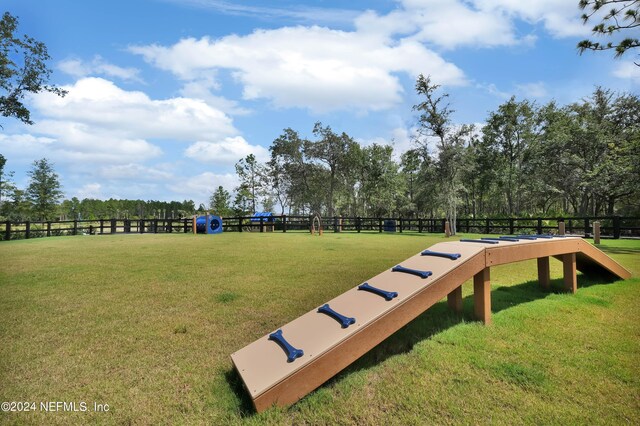 view of community featuring a lawn and fence