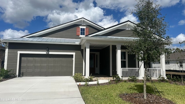 view of front facade featuring a porch, a front lawn, and a garage