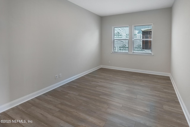 unfurnished room with light wood-type flooring and baseboards