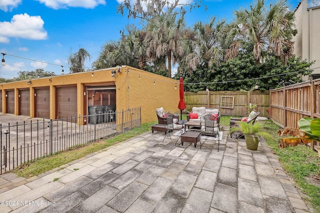 view of patio with outdoor lounge area and a garage