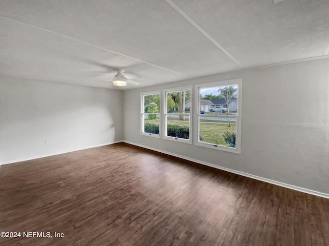 spare room with dark wood-type flooring and ceiling fan