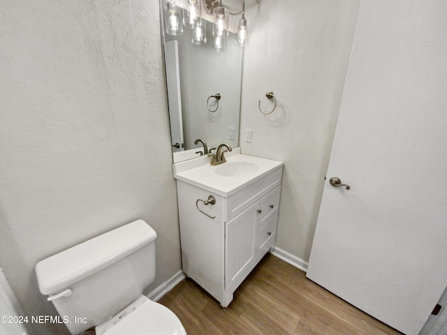 bathroom featuring vanity, toilet, and hardwood / wood-style floors