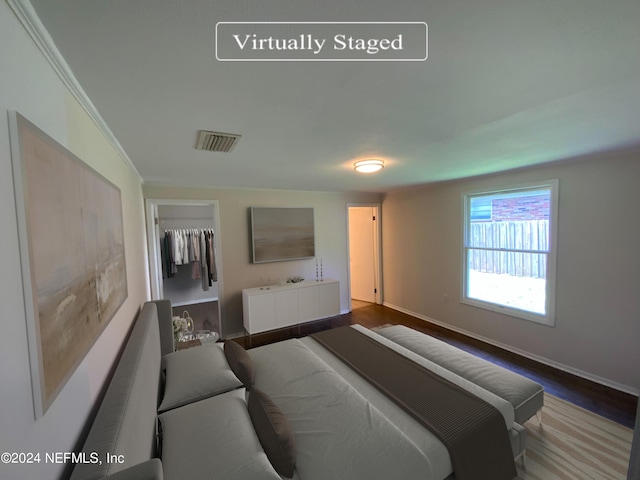 bedroom featuring crown molding, hardwood / wood-style flooring, and a closet