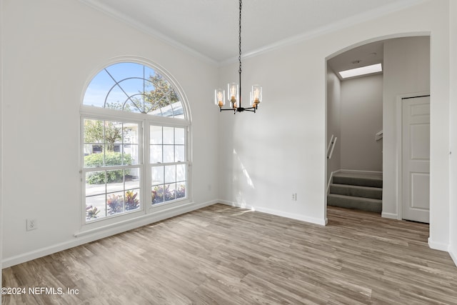 unfurnished dining area with crown molding, hardwood / wood-style flooring, and a chandelier