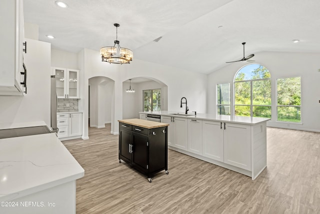 kitchen with sink, pendant lighting, a center island with sink, and white cabinets