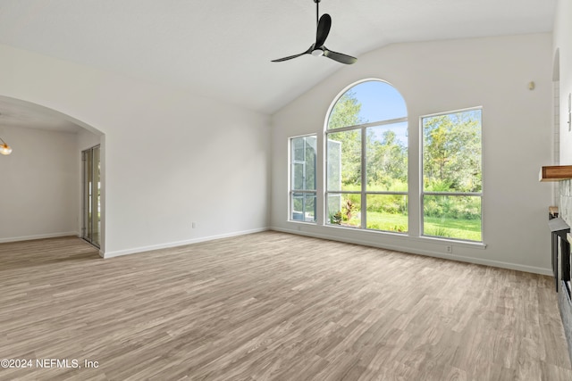 unfurnished living room with ceiling fan, light wood-type flooring, and vaulted ceiling