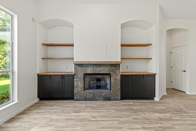 unfurnished living room with light hardwood / wood-style floors and a tile fireplace