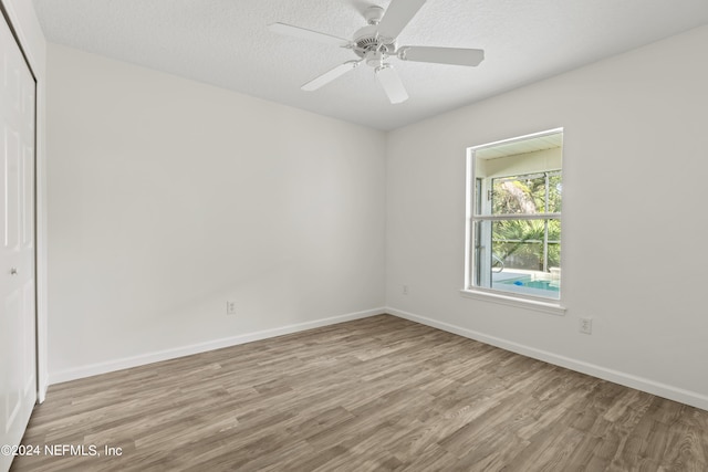 spare room featuring light hardwood / wood-style floors, a textured ceiling, and ceiling fan